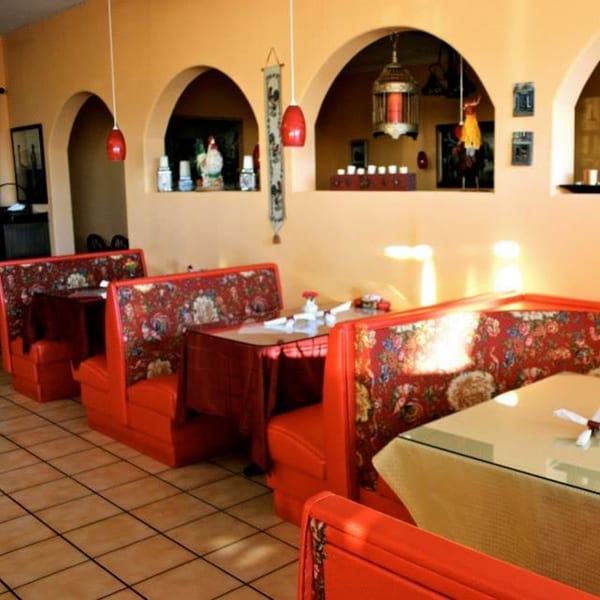 Interior of Crepe Town with red booths, patterned cushions, arched walls, and decorative lighting.