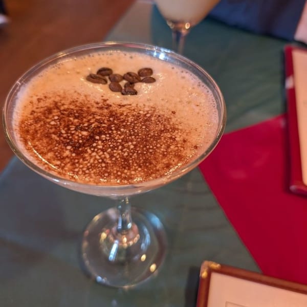 Espresso martini with coffee beans and cocoa powder on top, on a table at Crepe Town.